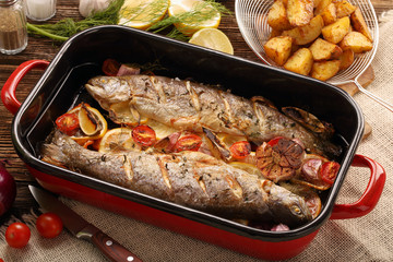 Baked fish with vegetables and potatoes in pan