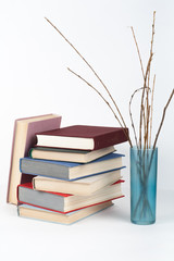 Open book, stack, hardback colorful books on wooden table, white background. Back to school. Copy space for text. Education business concept.