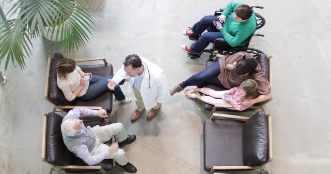 Overhead shot of Medical Doctor greeting Senior Male in waiting room