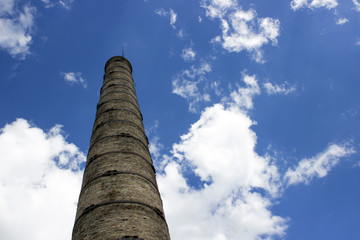 Factory, chimney оf brick, against the background of clouds