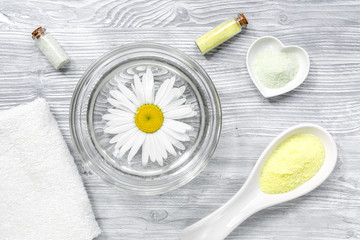 hands care set for manicure with chamomile on gray wooden background top view