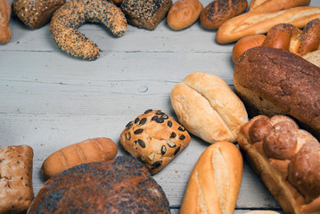 Assortment of baked bread on wooden rustic table background
