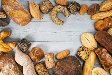 Assortment of baked bread on wooden rustic table background