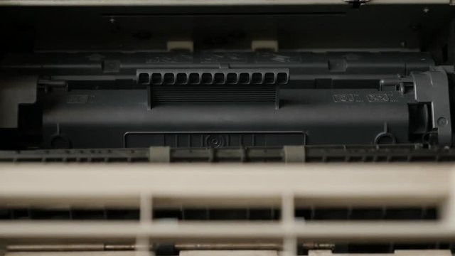 Close-up toner cartridge inside office printing device slow tilt 4K 2160p 30fps UltraHD footage - Details of modern laser printer interior 3840X2160 UHD tilting video