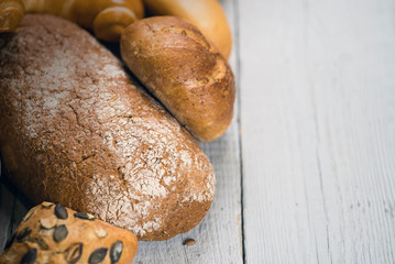 Assortment of baked bread on wooden rustic table background
