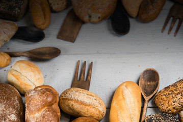 Assortment of baked bread on wooden rustic table background
