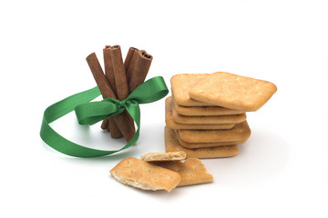Biscuits, cinnamon sticks with a green bow on a white background