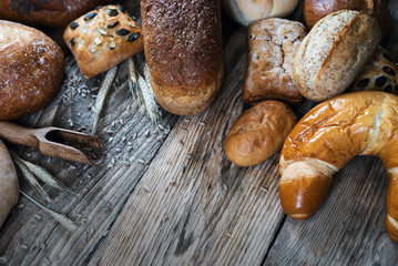 Assortment of baked bread on wooden rustic table background