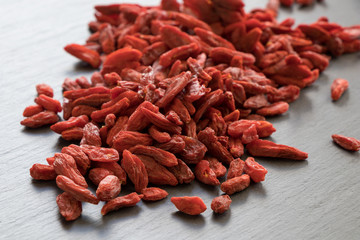 A pile of dried goji berries on a stone background