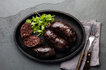 Bloody sausages, chilean prieta on cast iron plate. Slate background, top view