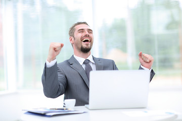 Portrait of happy businessman cheering at workplace