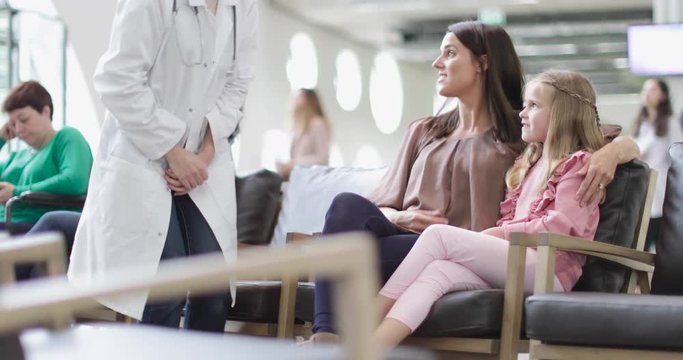 Mother and Child talking with Doctor in waiting room