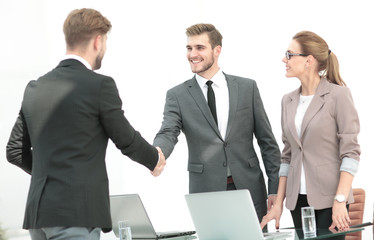 Fototapeta premium Happy smiling business people shaking hands after a deal in offi