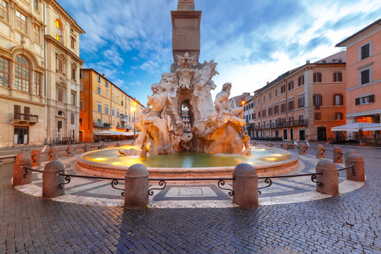 Fountain of the Four Rivers on the famous Piazza Navona Square during morning blue hour, Rome, Italy.