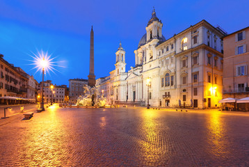 Fototapeta na wymiar Fountain of the Four Rivers with an Egyptian obelisk and Sant Agnese Church on the famous Piazza Navona Square at night, Rome, Italy.