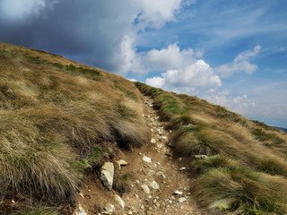 Hiking trail against cloudy sky