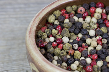 Closeup image of a bowl full of colorful peppercorns.