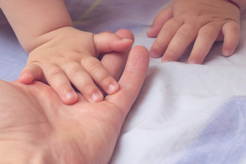 The hand of the child in the father's hand