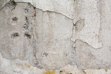 Grunge wall worn, rough masonry, cracks on the wall, plaster fell