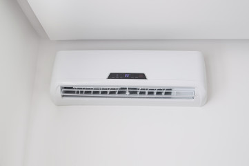 White split air conditioner on a white wall. Home interior in a small apartment
