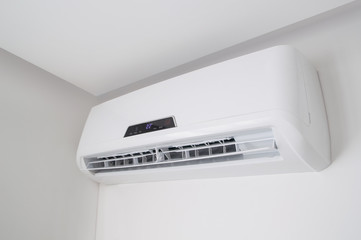 White split air conditioner on a white wall. Home interior in a small apartment