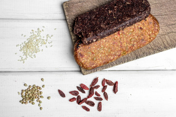 Bio gluten free protein bar with components and copyspace sign on wooden table.