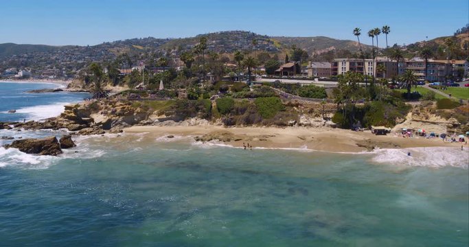 Perfect aerial wide shot of a Malibu California beach with white water waves crashing on the sand from a helicopter point of view showing the sea and coastline in Los Angeles, United States