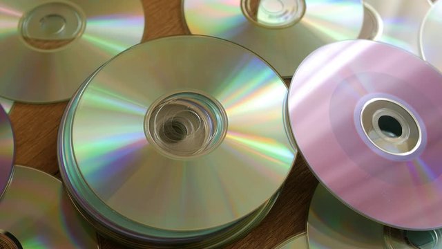 Optical Discs falling onto big pile of DVDs or CDs.