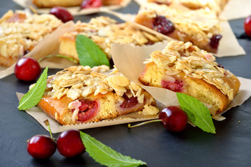 Geschnittener Kirsch-Hefekuchen mit Florentiner-Knusper-Karamel (Blechkuchen,  österr. Germkuchen mit frischen Kirschen und Honigmandeln) -  Yeast cake with fresh cherries  and crunchy almond caramel