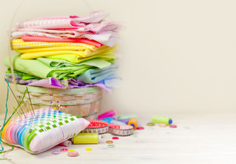 Accessories for sewing lie on a white background. Measuring tape, thread, fabric, needle bar and...