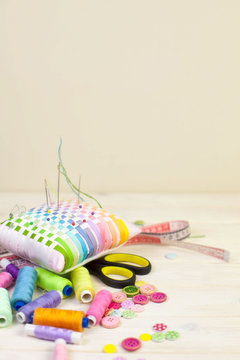 Accessories for sewing lie on a white background. Measuring tape, thread, fabric, needle bar and needles for sewing.