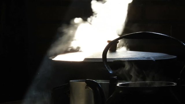 Rustic Brazilian farmhouse cooking. Close up of large pan and big black metal kettle