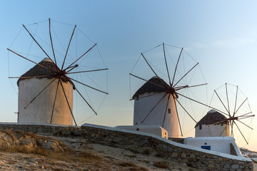 Fototapeta na wymiar Sunset of White windmills and Aegean sea on the island of Mykonos, Cyclades, Greece