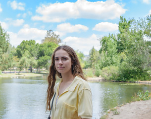 Young woman stops by the lake on sunny day