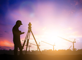 silhouette survey engineer working  in a building site over Blurred construction worker on...