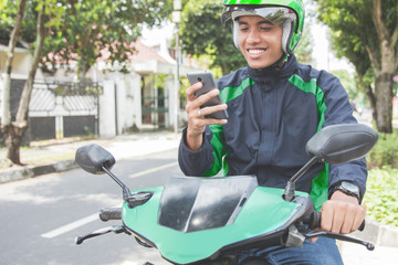 motorcycle taxi driver taking order via mobile phone online app