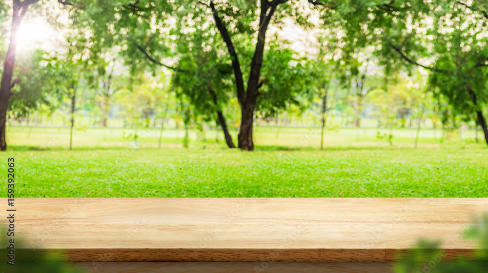 Aufkleber empty wood table top with blur park green nature bokeh and leaf foreground,mock up for display or mo