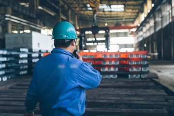 worker using walkie-talkie in a metal factory,industry zone.