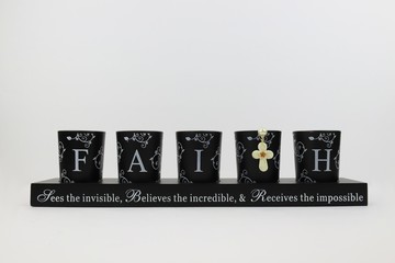 Inspirational candle holders with rosary cross spelling out faith 