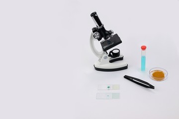 Microscope with slides and forceps and other lab equipment centered right