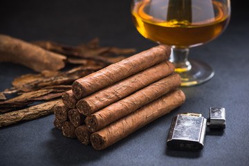 Many cuban cigars in stack with cognac