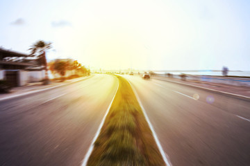 Naklejka premium view of a road in motion blur effect and sun flares