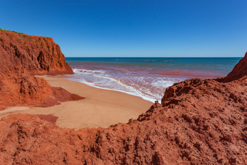 Fototapeta na wymiar Waves at high tides breaking against the red pindan cliffs at James Price Point, Western Australia