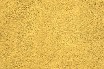 A wall with a rough surface is painted in lemon color