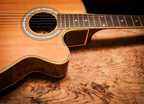 Vintage acoustic guitar on rustic wood background.