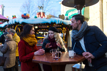 Freude treffen sich auf einem Weihnachtsmarkt und stoßen mit Glühwein an