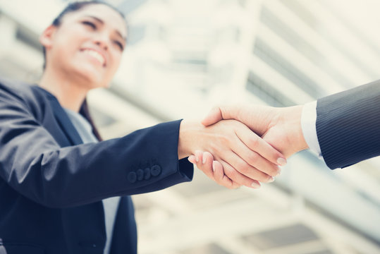 Businesswoman making handshake with a businessman - vintage tone effect