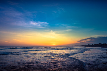 Fototapeta na wymiar Sunset Background Ocean. Tropical Sunlight and Summer Sunset View. Colorful Background Sunset. Blue Waves near sea Resort. Sea sunset Background. Colorful Beach with Surfers on the Horizon. Landscape