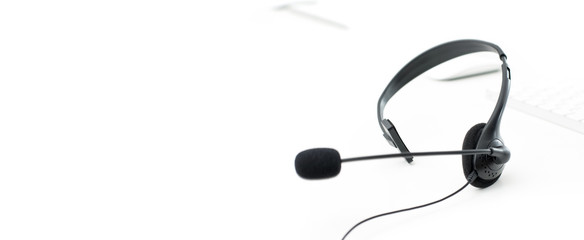 Microphone headset on white table with computer keyboard