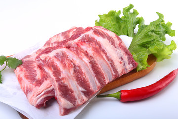 Raw pork ribs with herbs and spices on wooden board. Ready for cooking.